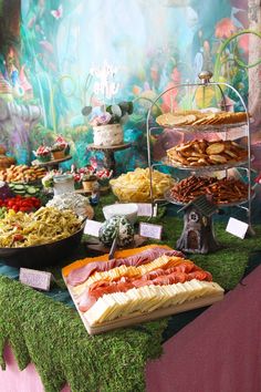 a table filled with lots of food on top of a green cloth covered tablecloth