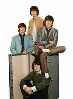 the beatles are sitting on top of their suitcases and posing for a photo together