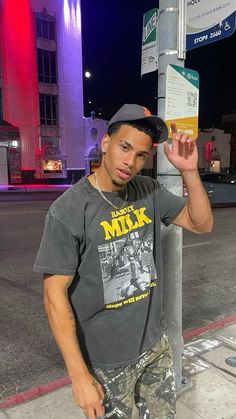 a young man standing next to a street sign