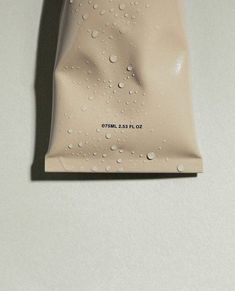 a bag with water drops on it sitting on a white counter top next to a black object