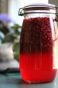 a jar filled with cranberry liqueur sitting on top of a table