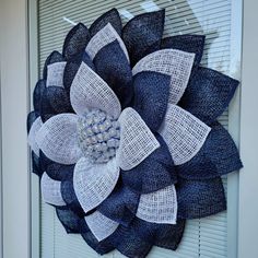 a blue and white flower is hanging on the front door