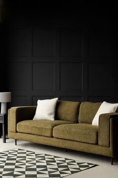 a living room with black walls and white rugs on the floor, two chairs and a couch