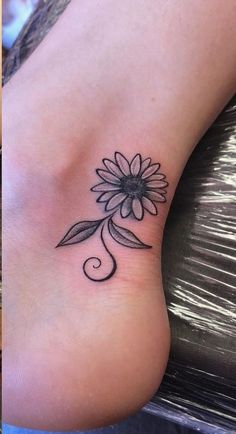 a small sunflower tattoo on the foot