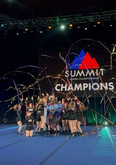 a group of women standing on top of a stage holding confetti in front of them