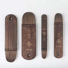 three pieces of wood that have writing on them and some are in the shape of knives