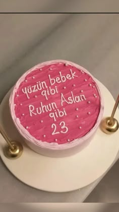 a pink cake with white writing on it