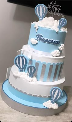 a three tiered cake with hot air balloons on top