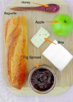 a wooden tray topped with bread, cheese and other food items on top of it