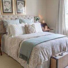 a bedroom with a large bed and two pictures on the wall