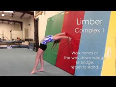 a woman doing a handstand on the side of a wall in a gym