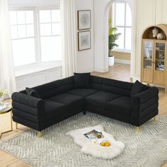 a black sectional sofa sitting on top of a rug