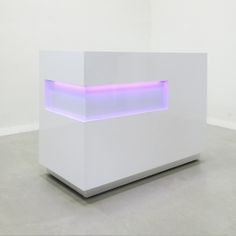 a white sculpture with blue lights on it's sides and an illuminated shelf in the middle