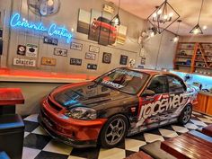 a car is parked in the middle of a checkerboard floored restaurant area