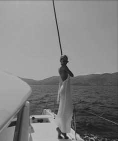 a woman in a towel standing on the back of a boat