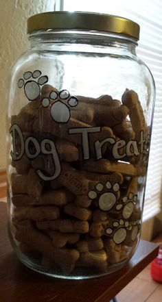 a glass jar filled with dog treats on top of a table