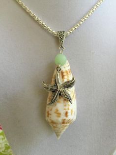 a necklace with a starfish on it and a green bead hanging from the back