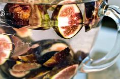 a pitcher filled with sliced figs on top of a table