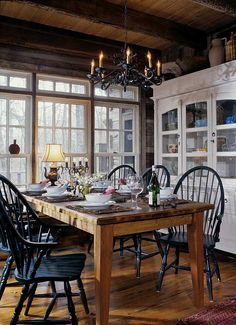 an old black and white photo of a dining room table set for four with chairs