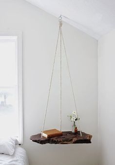 a bedroom with a bed, table and hanging planter