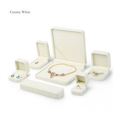 an assortment of jewelry in white boxes on a white background with the words creamy white written below it