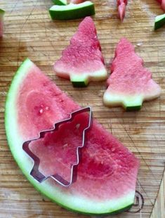 watermelon slices cut into christmas trees on a cutting board