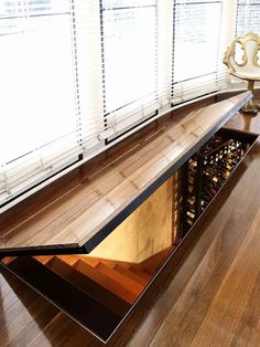 an advertisement for a wine cellar in the middle of a room with wooden floors and windows