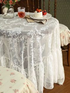 the table is covered with white lace and flowers