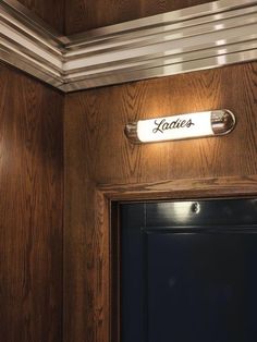 a door with a name plate on it and a light above the door that says kotters