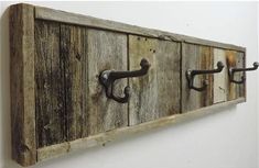 an old wooden coat rack with metal handles and hooks on the front, hanging from a wall