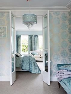 an open door leading to a bedroom with blue and white decor on the outside wall