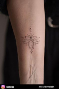 a woman's arm with a flower tattoo on the back of her left arm