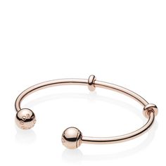 A sleek addition to your jewelry box, Pandora's 14K rose gold-plated Pandora Moments Open Bangle is minimally detailed with silicone stoppers that double as adornments. The polished style is plated with 14K rose gold for a warm finish. The logo-embossed end caps are easily removed to add charms — and are interchangeable to suit your mood. Adjustable Modern Rose Gold Bangle, Modern Adjustable Rose Gold Bracelets, Classic Adjustable Rose Gold Bangle, Pandora Logo, Pandora Rose Gold, Open Bangle Bracelet, Pandora Rose, Polished Style, Bracelet Pandora