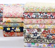 a stack of colorful floral fabric on top of each other in various sizes and colors