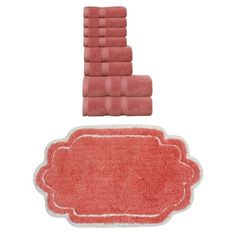 towels and bath mats are arranged on top of each other, including one with a pink border