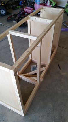 an unfinished cabinet is sitting on the floor next to other woodworking supplies and tools