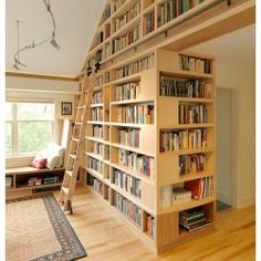 there is a bookshelf full of books in the living room with ladders