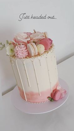 a white cake with pink icing and flowers on top