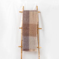 a brown and tan plaid blanket hanging on a wooden rack