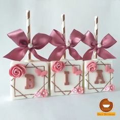 three blocks with pink flowers and bows on them