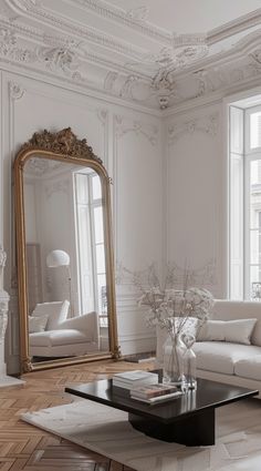 a living room with a couch, coffee table and large mirror