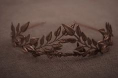 a tiara with leaves on it sitting on top of a cloth covered tablecloth