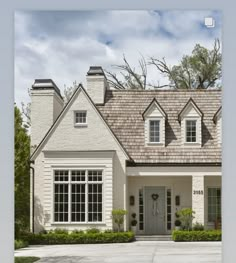 a white house with two windows and a gray roof