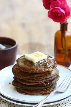 a stack of pancakes on a plate with butter and syrup