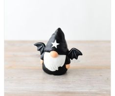 a black and white figurine with a star on it's head sitting on a wooden table