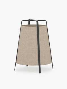 a lamp shade with black metal frame and beige fabric on the bottom, against a white background