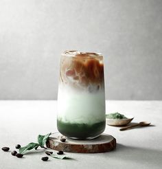 a green and white drink sitting on top of a table