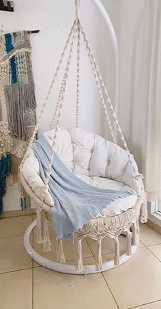 a hammock chair with a blue blanket on it in front of a window