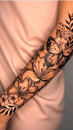 a woman's arm with flowers and butterflies on it