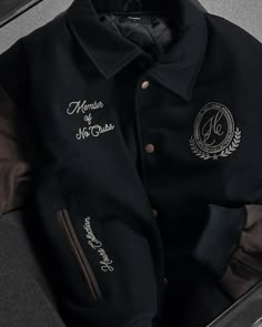 This varsity jacket is made from 100% wool body with premium leather sleeves and accents. It features a relaxed cropped fit with a folded collar and snap button closure. The jacket is also decorated with chain stitch embroidery throughout and comes in two different colorways. 100% wool body Premium leather sleeves & accents Chain stitch embroidery Inner lining for extra comfort and warmth Embroidery Leather Jacket, Embroidery On Jacket, Mens Clothing Styles Winter, Letter Man Jacket, Jacket Design Ideas, Jacket With Pins, Hoodie Design Inspiration, Letterman Jacket Ideas, Kingdom Spouse